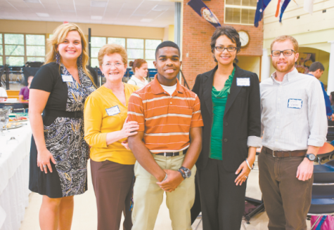 Joshua Y. posing with his business sponsors from his internship.
