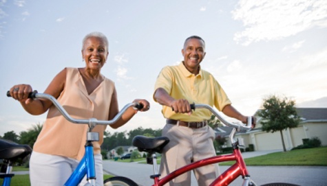 Senior African American couple with bicycles on residential street